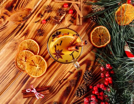 One glasses mulled white wine on a rustic wooden table. Selective focus, copy space background, top view, flat lay. Still life, dry oranges decor, seasonal and holidays concept. Christmas and autumn themeの写真素材