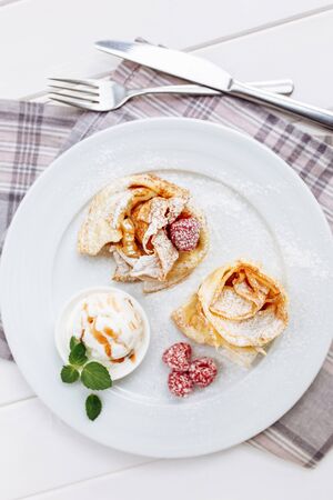 Crepes Pancakes with fruit jam and ice cream. Top view on white wooden tableの写真素材