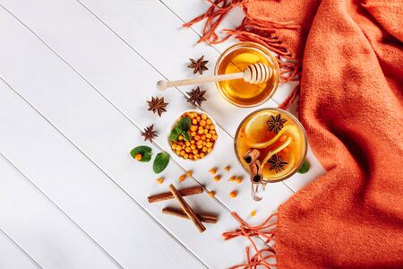 Sea buckthorn tea in wooden bowl, honey, Sea buckthorn juice on white wooden table. top view with copy space for textの写真素材