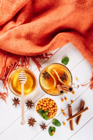 Sea buckthorn tea in wooden bowl, honey, Sea buckthorn juice on white wooden table. top view with copy space for textの写真素材