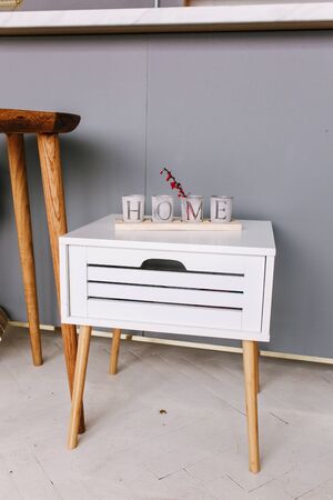 White wood bedside table. Modern designer, nightstand with letters cubes homeの写真素材