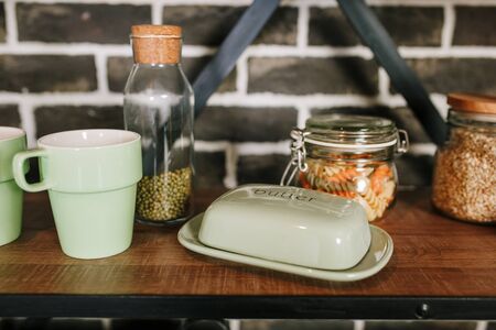Utensils and mugs on shelfの写真素材