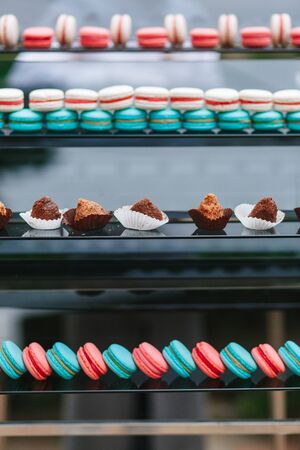 Macaroon and chocolate cakes rows on glass shop case. Assorted for wedding cateringの写真素材