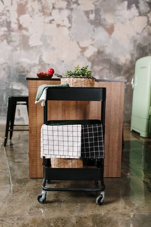 Cozy loft kitchen with dinning table, chairs and metal storage racks on wheels - trolleyの写真素材