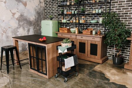 Dining area in industrial style with table, chairs and mint retro fridge. Black vintage brick wall backgroundの写真素材