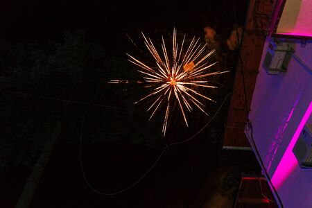 One firework burst near hotel wall on dark black sky backgroundの写真素材