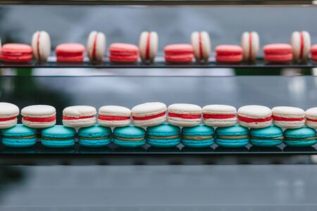 Colorful french macarons for sale in shop. raws of macaroons in candy shop, storefront with sweets. Traditional french pastryの写真素材