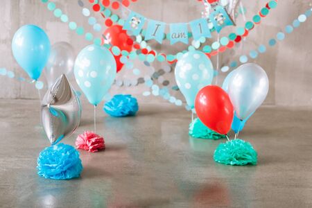 Festive background decoration for birthday celebration, letters saying one and colorful balloons in studio, cake smash first year conceptの写真素材