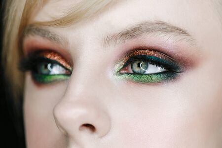 beautiful young model with green-brown smoky eyeshadow evening make up, perfect skin. Close-up face portraitの写真素材