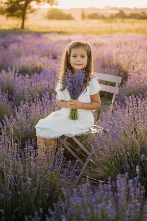 Peaceful Little Girl Sitting on Lavender Fieldの写真素材