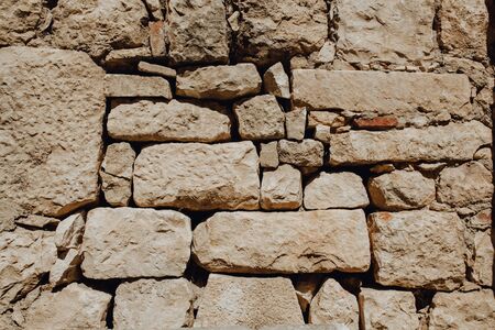 Old Stone Wall Rock Construction Background. Large Beige Block Surface Architecture Construction Concept Historical Building CloseUp. Macro Photo of Ancient Structure Landscape Viewの写真素材