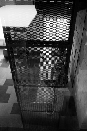 Rusty Metal Grid Industrial Office Loft Style Interior Monochrome Photography. Grunge Rusted Iron Construction Fence, Foam Brick Wall and Design Carpet. Stylish Business Workplace Sceneの写真素材