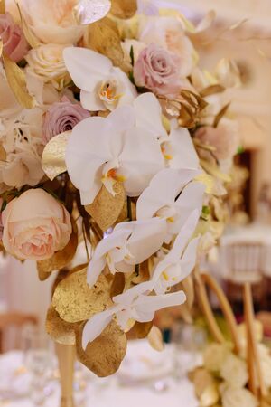 Decorative Bouquet of Beautiful Flowers Closeup Photography. Romantic Floral Traditional Accessory Decorated Golden Leaves for Decorate Dining Table. Fashion Luxury Restaurant Ornamentの写真素材