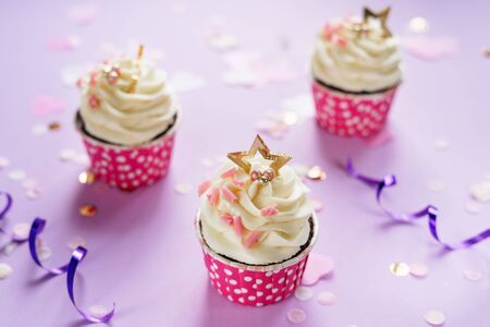 Creamy Cupcakes Dessert with Rose Chocolate Chips Decorated Delicious Balls and Golden Star on Top. Festive Cakes and Celebration Confetti. Homemade Baked Food Horizontal Photographyの写真素材