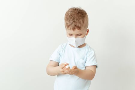 Little Boy in Medical Mask Using Sanitiser Bottleの写真素材