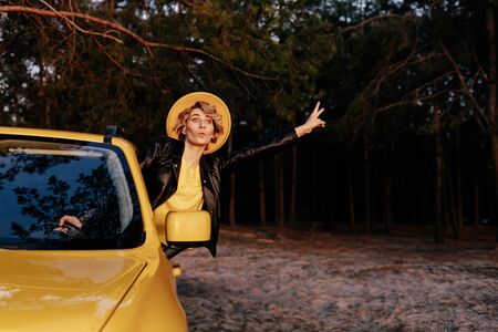 Caucasian Funny Woman Leaning out of Car Windowの写真素材