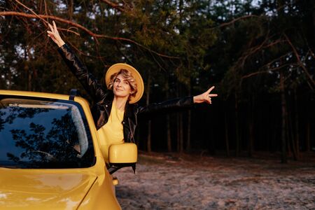 Caucasian Smiling Woman Leaning out of Car Windowの写真素材