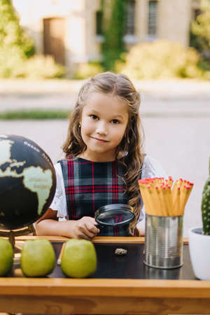 Cute Primary Schoolgirl Smile Sit At Desk Outdoorsの写真素材