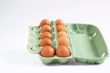 brown eggs, recycled paper container on a white backgroundの写真素材