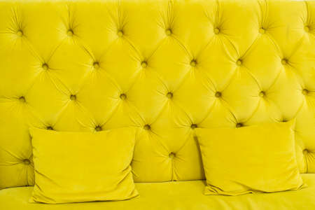yellow quilted sofa with yellow soft pillowsの写真素材