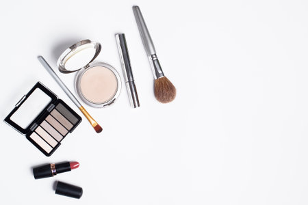The powder, eye shadow, mascara, brushes are on a white background. Cosmetics for women on a white background and a place for textの写真素材