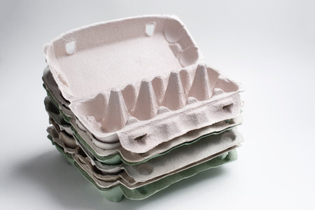 the lot of empty packages for fresh eggs made of recycled cardboard on a light background
