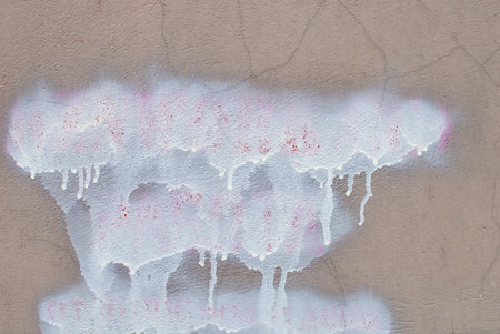 the texture of the paint with white smudges on the brown stone wallの写真素材