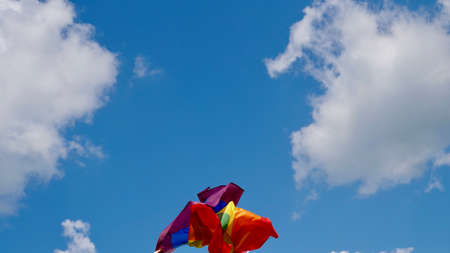 LGBT flag against blue sky with clouds on a sunny day and Celebrate Bisexuality Day or National Coming Out Dayの写真素材