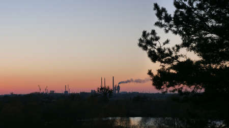 The industrial plant operates and pollutes the environment, nature at sunset. Ecological world catastrophe of factoriesの写真素材
