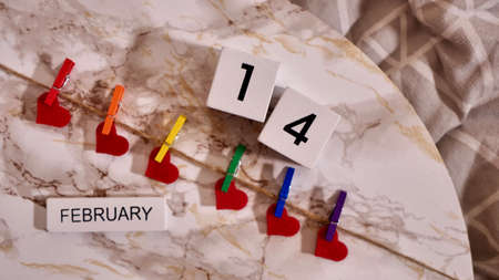 Happy Valentines Day LGBTQIA, colored rainbow clothespins with red hearts and text, on marble background close up.の写真素材