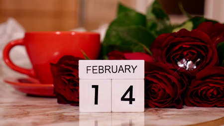 Background Festive Flatlay, composition for Valentines Day on February 14. Coffee in a red cup, red rose flowers and diamond heart earrings at home in bedの写真素材