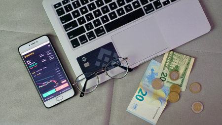 Laptop and phone to buy bitcoin on the Binance crypto exchange during the market crash. Trading, spot, staking. Workspace freelance flatlayのeditorial素材