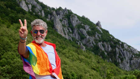 Portrait of a gray-haired senior elderly Caucasian man bisexuality with a beard and sunglasses with...