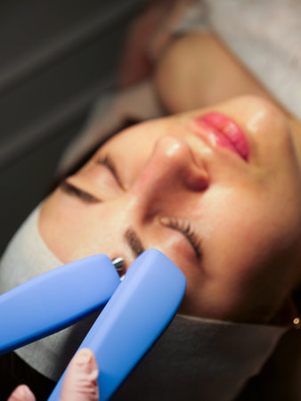 Cosmetic procedure for a woman Microcurrents for a womans face at a beautician. Rejuvenating effect,...