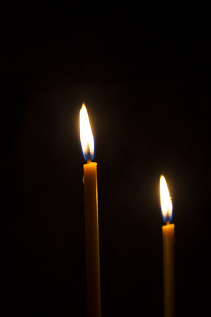 Church candles burning in the darkの写真素材