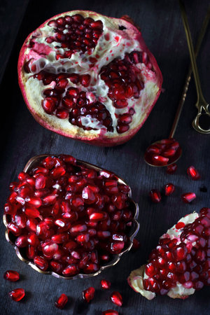 pomegranate and pomegranate seeds on a dark backgroundの写真素材