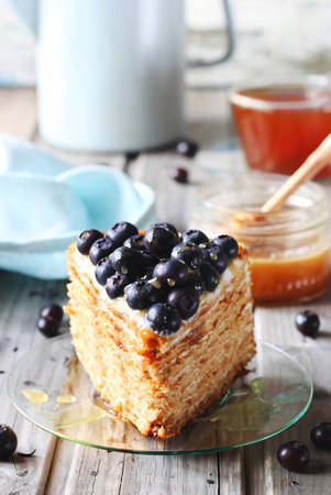 Piece of honey cake decorated with blueberry and honey on glass dishの写真素材