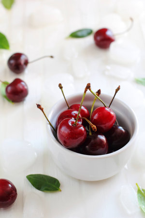 ripe cherries in a white bowl, shot with natural lightの写真素材