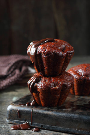 chocolate banana muffins topped with melted chocolate, shot with natural lightの写真素材