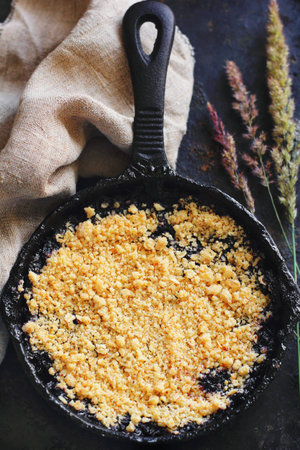 homemade blueberry crumble in a cast iron pan, shot with natural lightの写真素材