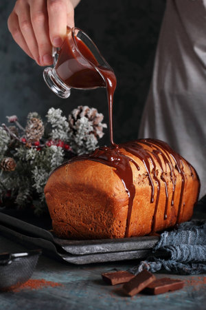 woman pours melted chocolate on a chocolate cake, in New Year's decorationsの写真素材