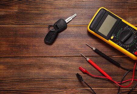 New keys on wooden background, top view on car keys and repair