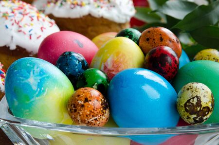 Easter eggs on the background of several Easter cakesの写真素材