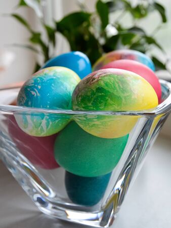 Easter eggs. Beautifully painted chicken and quail eggs in a crystal vaseの写真素材