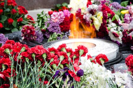 Eternal flame. At the monument to fallen soldiers. Flowers by the fire.の写真素材