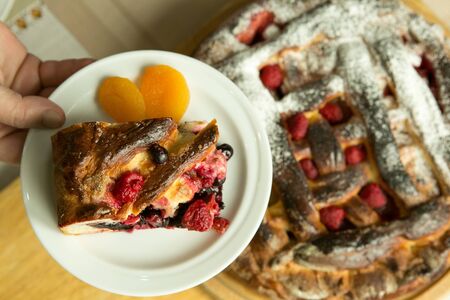 Mom's pies. The pies are ready. A piece of cake on a plate against the background of a baked cake....