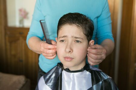 Home haircut during quarantine. The best master is mother's hands, scissors and a trimmer.