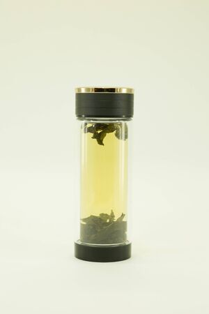 Chinese green tea. Ginseng tea Xiao Zhong is brewed in a double glass thermo dish. Isolated on a white backgroundの写真素材