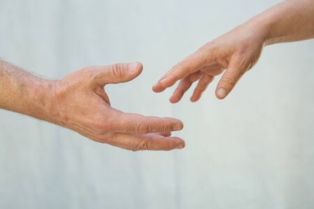 The concept of emotions. The man's hand tries to hold the departing woman's hand.の写真素材