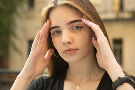 Portrait of a young girl. The concept of emotions. A girl enjoys a walk around the city after...